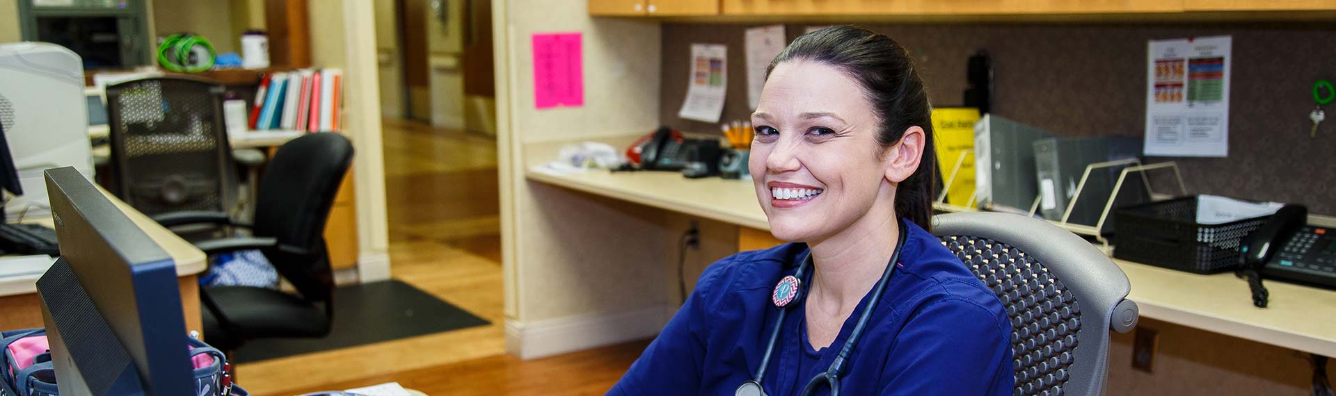 nurse at desk smiling